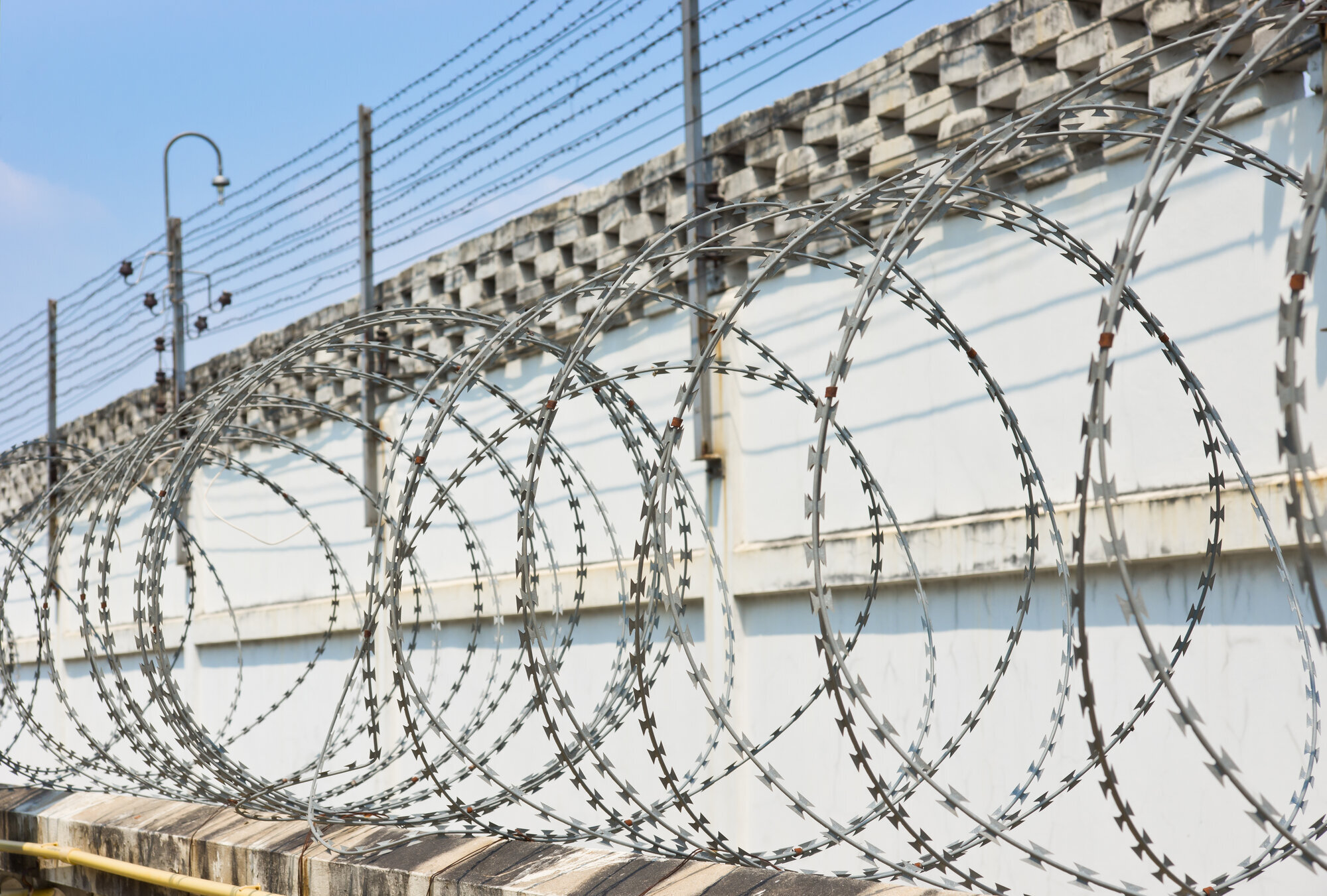 Bilde av piggtråd og gjerde rundt et fengsel Bilde av piggtråd og gjerde rundt et fengsel