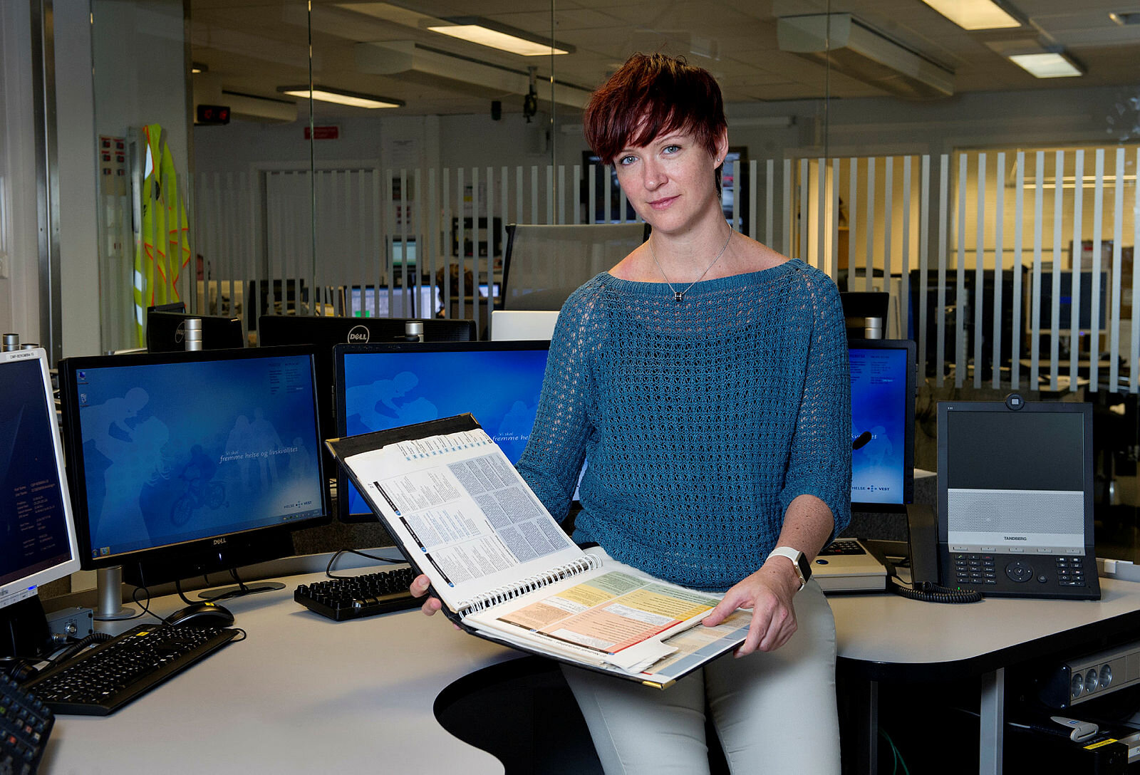 Eirin Ellensen Bildet er et portrett av lege Eirin Ellensen på en AMK-sentral med Norsk indeks for medisinsk nødhjelp i hendene.