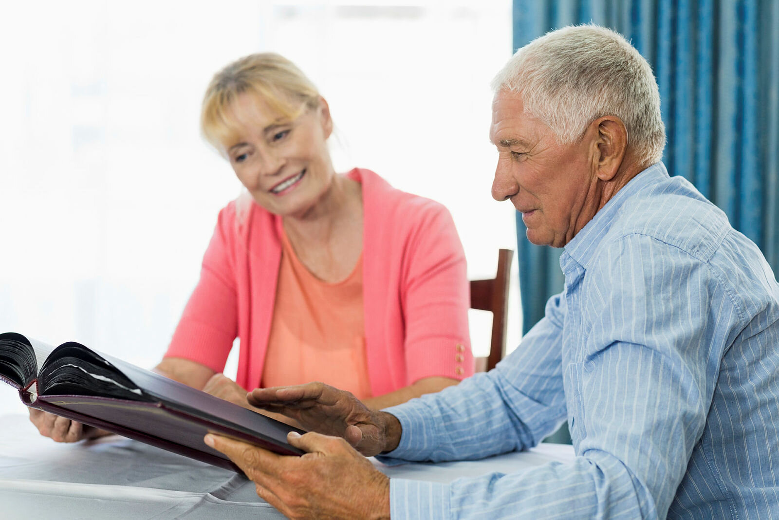 Senior couple looking at photo album Senior couple looking at photo album in a retirement home