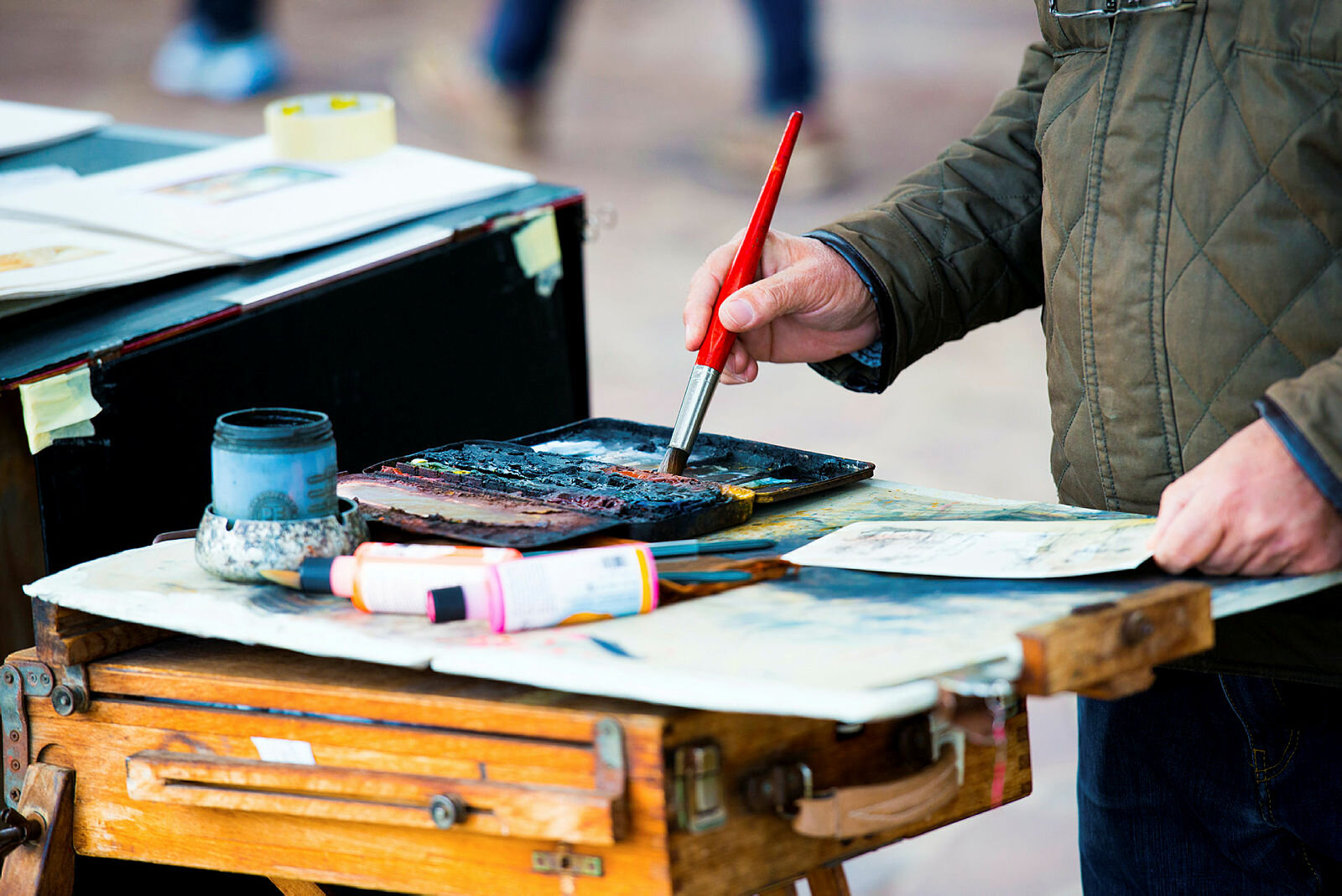 Male Bildet viser hender som tar maling på en pensel for å male et bilde
