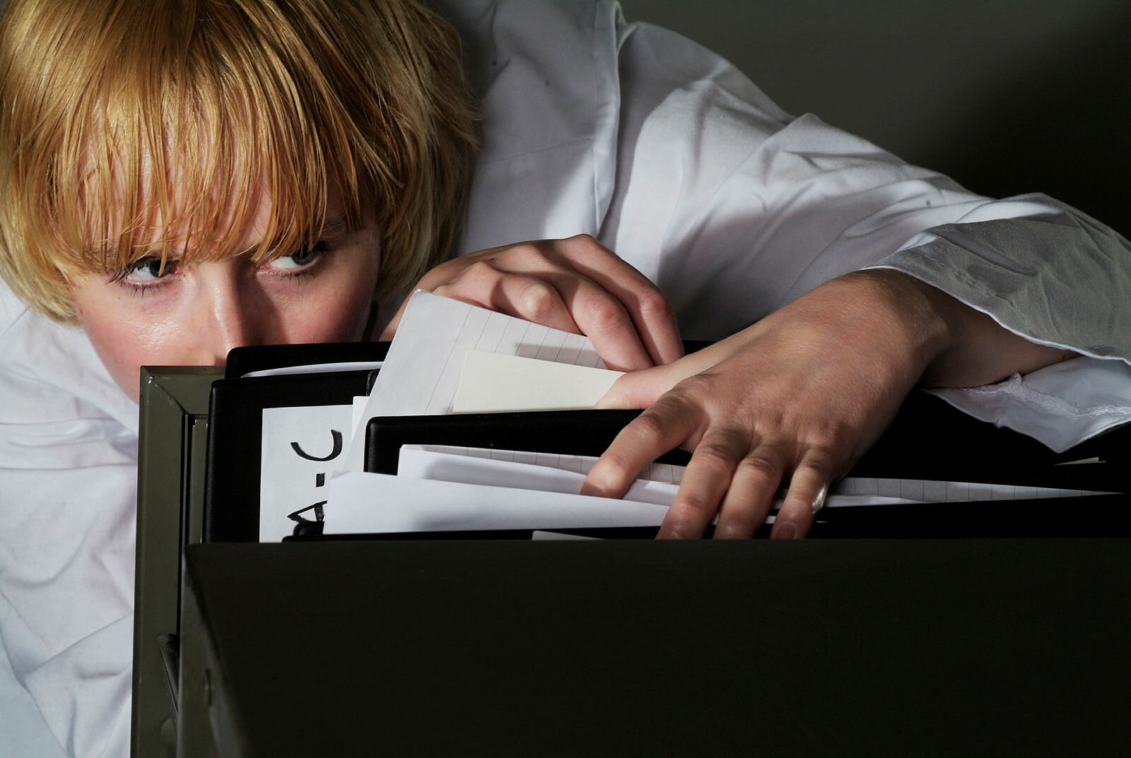 Kvinne som ser i arkiv, papirer eller journaler.