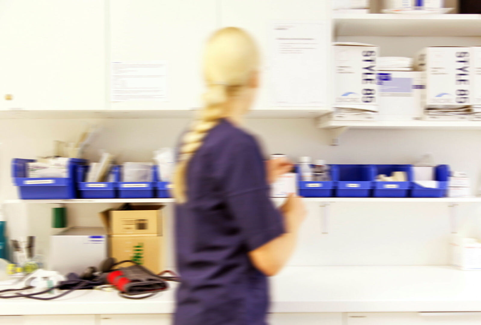 Sykepleier på vakt Bildet viser en sykepleier som finner frem medisiner på et medisinrom.