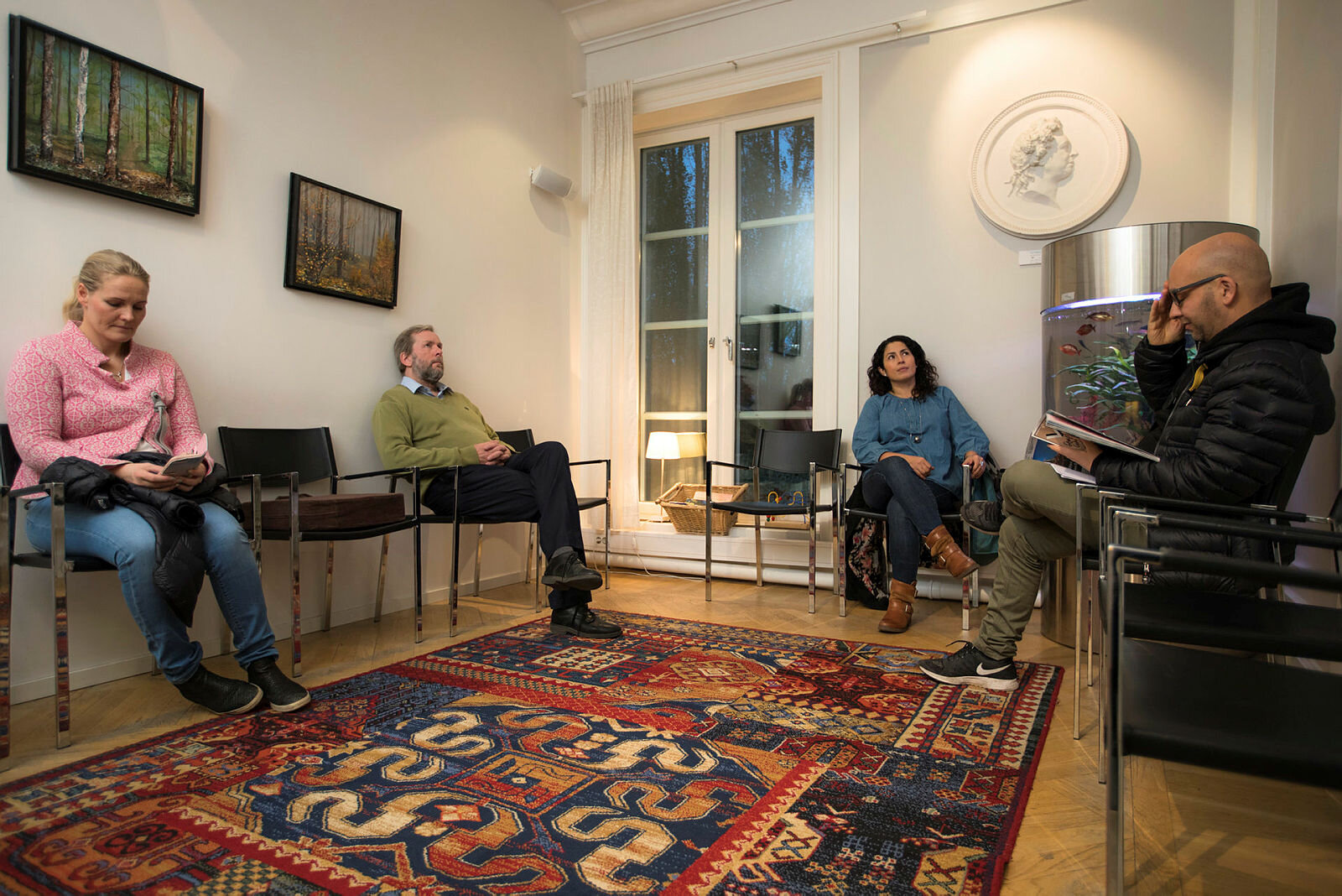 Venterom Bildet viser fire personer som sitter i et venterom