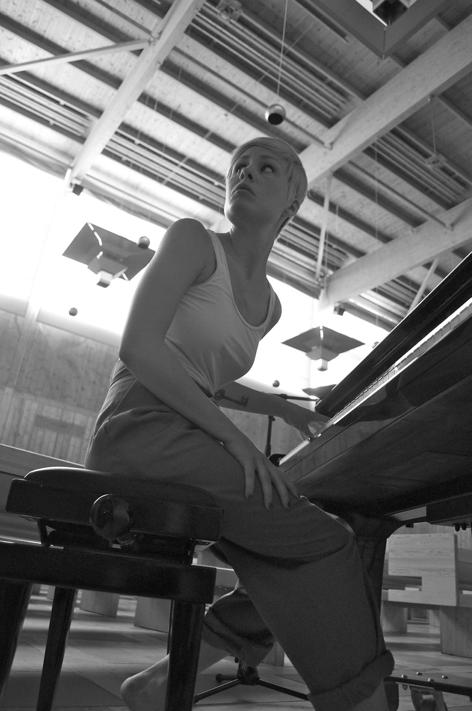 Piano Bildet viser en ung kvinne som sitter ved et piano
