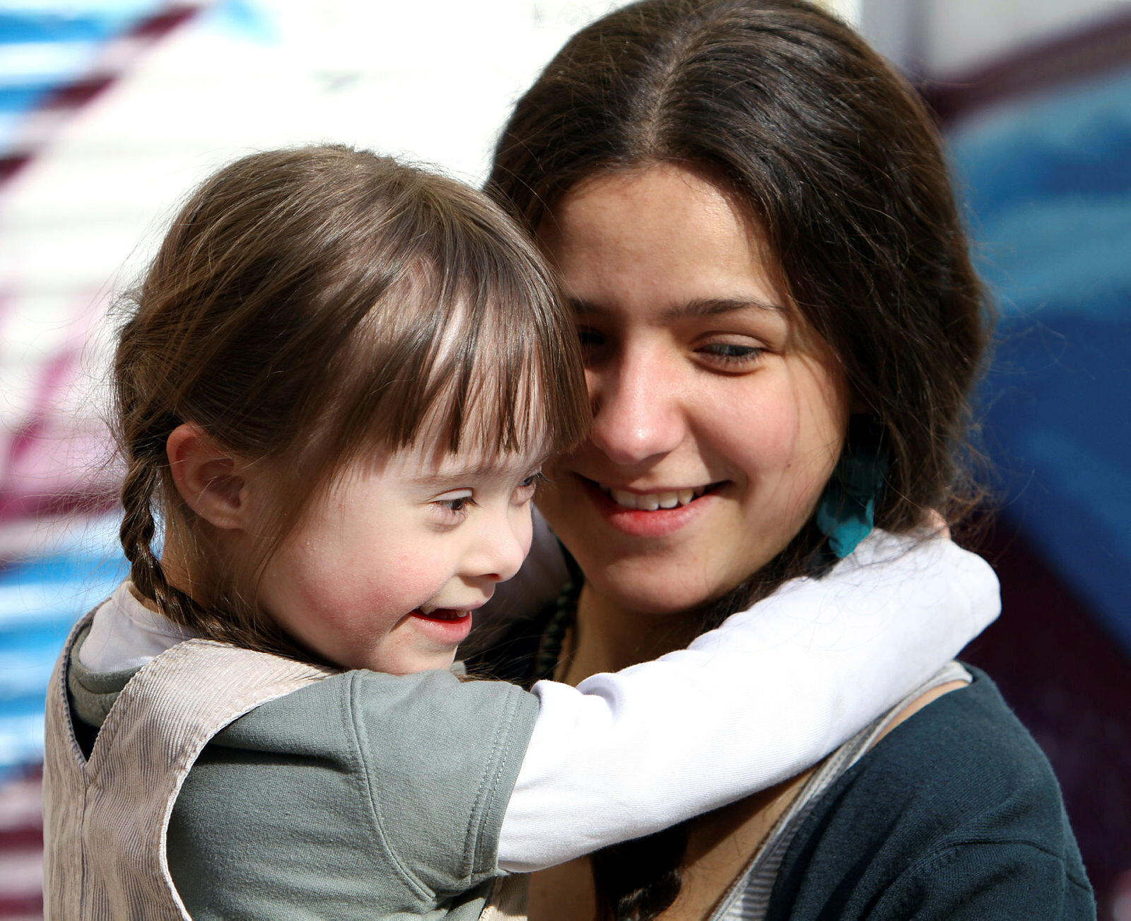 Mor og barn med Downs syndrom Bildet viser en lykkelig mor som holder en glad datter, som har Downs syndrom