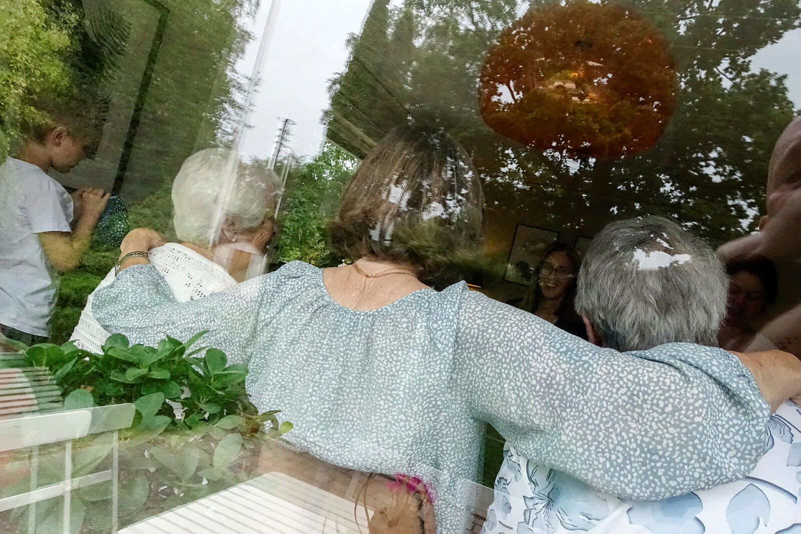 Eldre Eldre personer sett bakfra gjennom et vindu.