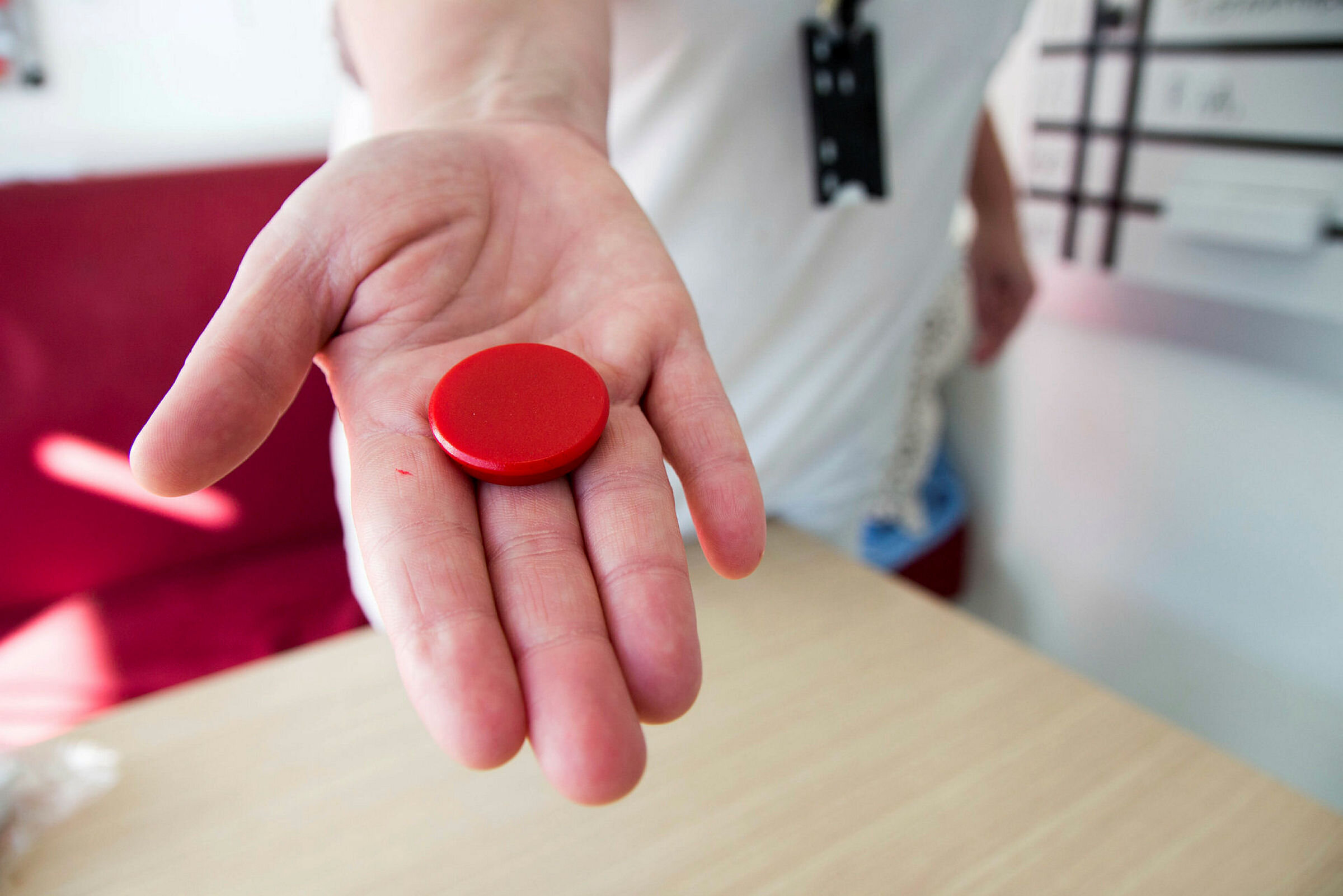 Dårlig magefølelse-knapp på gastrokirurgen på Ahus Bildet viser en hånd som holder en rød magnet.
