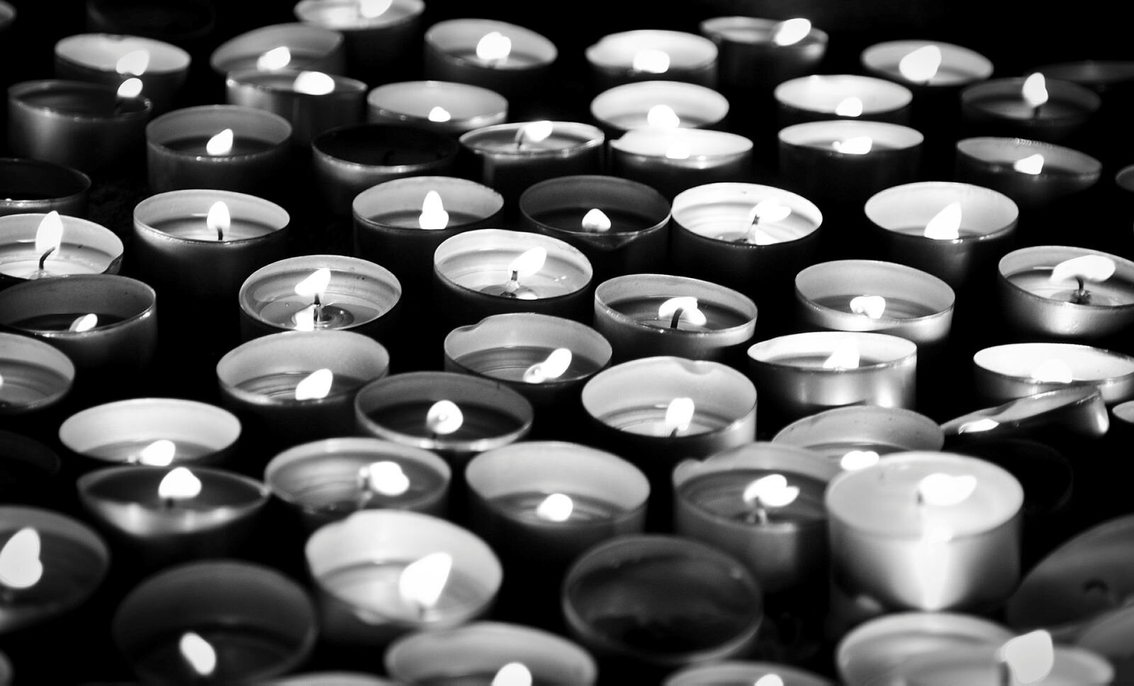 Lys Bildet er svart-hvitt og viser mange telys som holder på å brenne ut