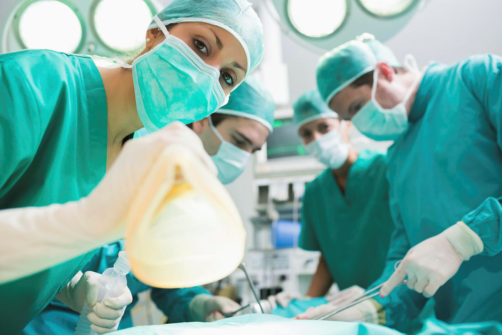 Operasjon Sykepleiere og leger som er på en operasjonsstue og klargjør en pasient til narkose.