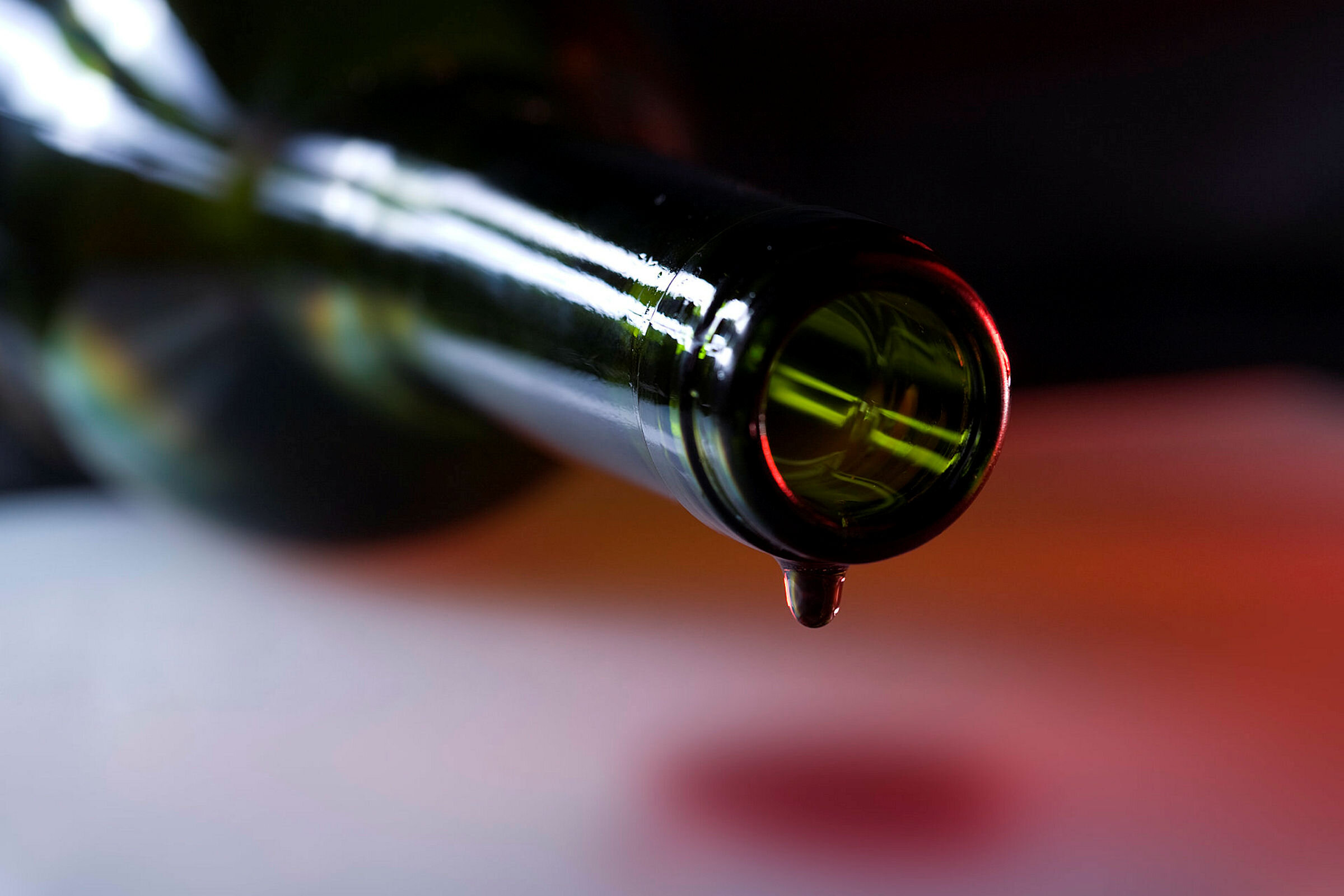 Bilde av rødvin som helles ut av en flaske