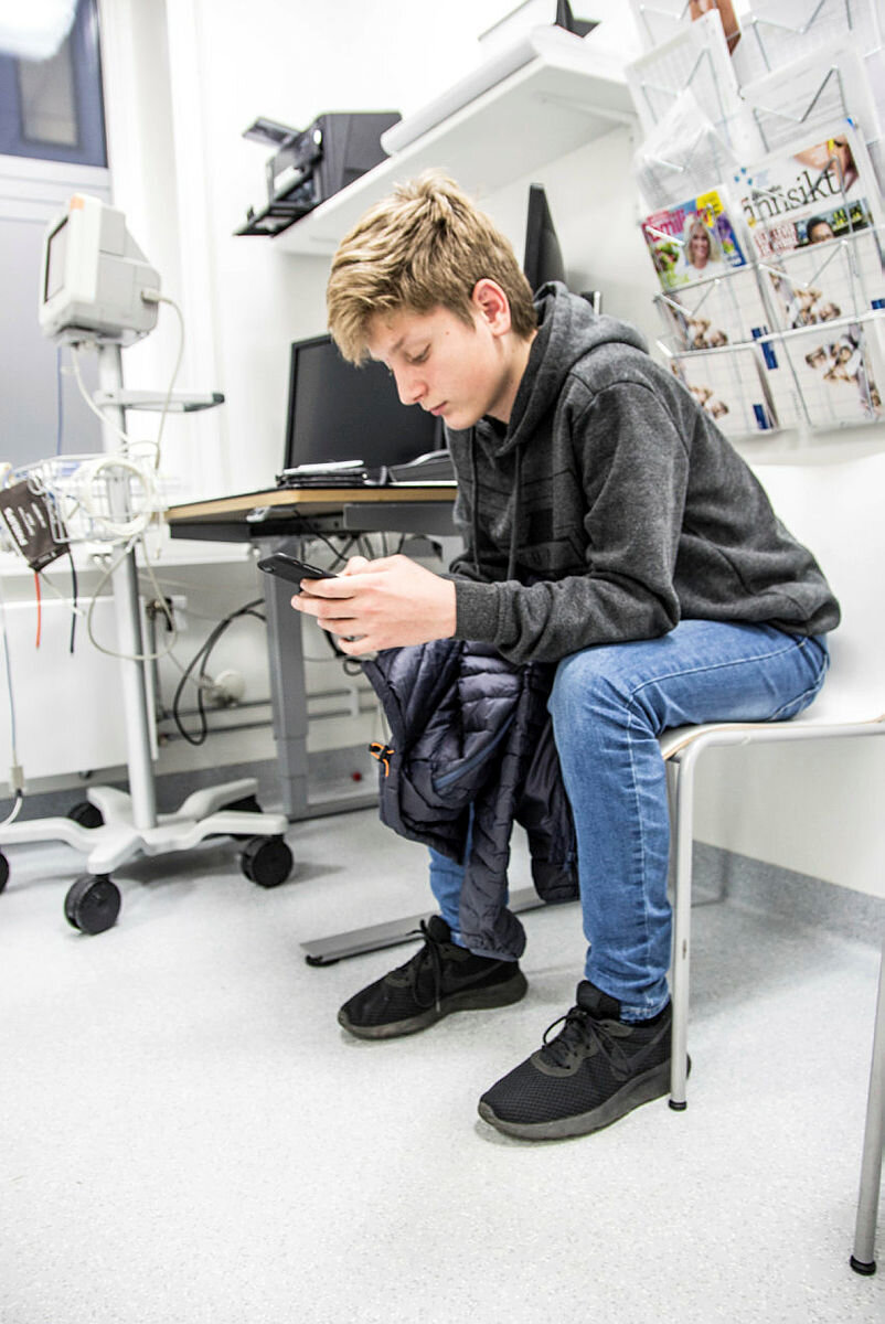 Lystgass på Sykehuset Østfold Bildet viser Emre Daniel Özkan som ser på mobilen sin.