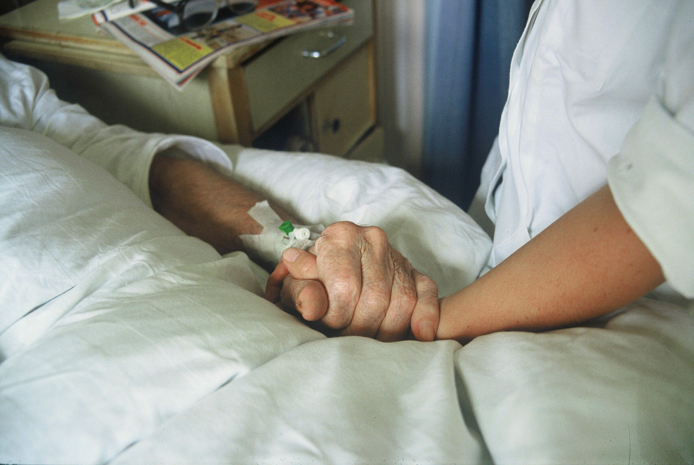 Hender Sykepleier holder eldre pasient i hånden