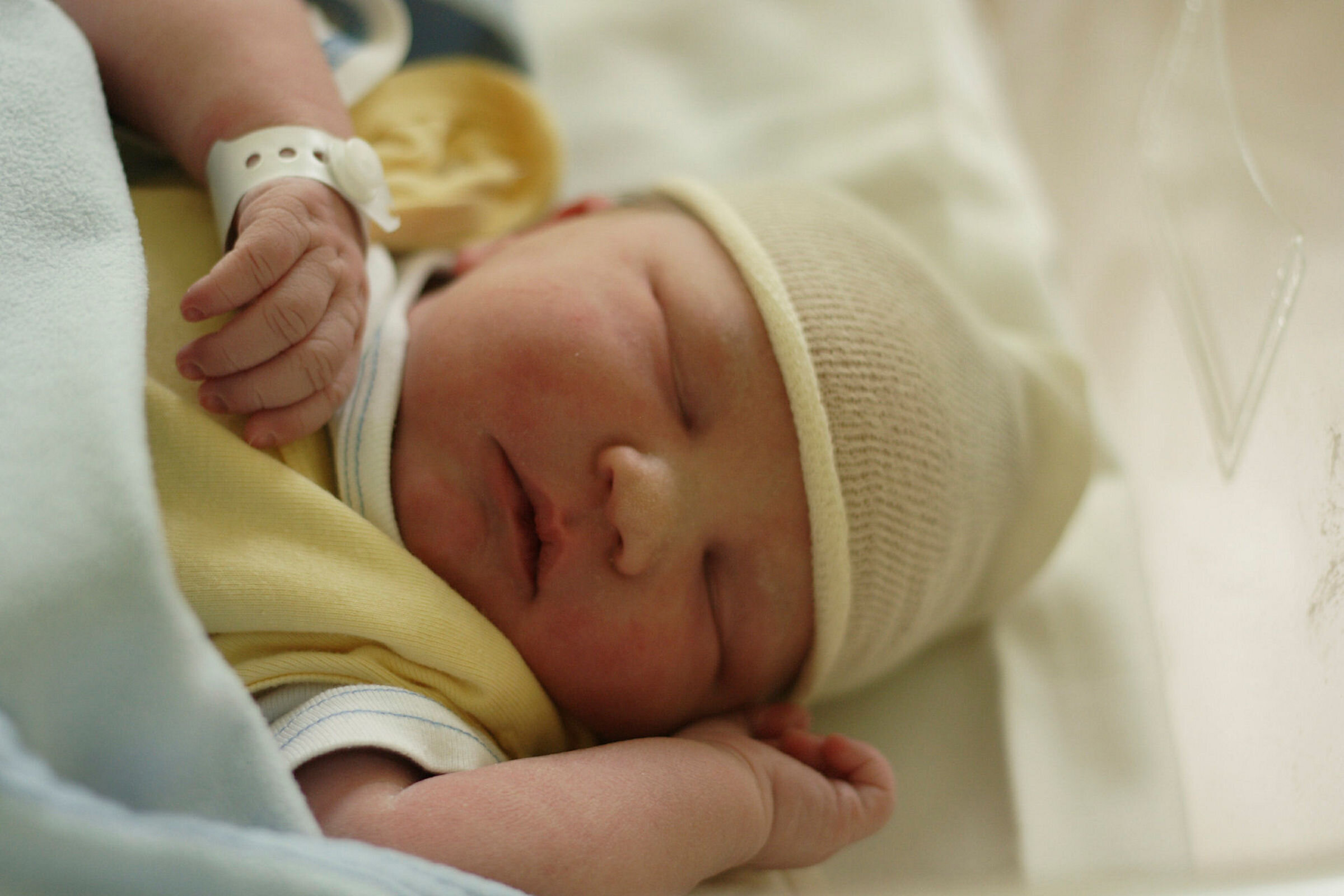 Nyfødt baby Bildet viser en nyfødt baby påkledd i sengen.