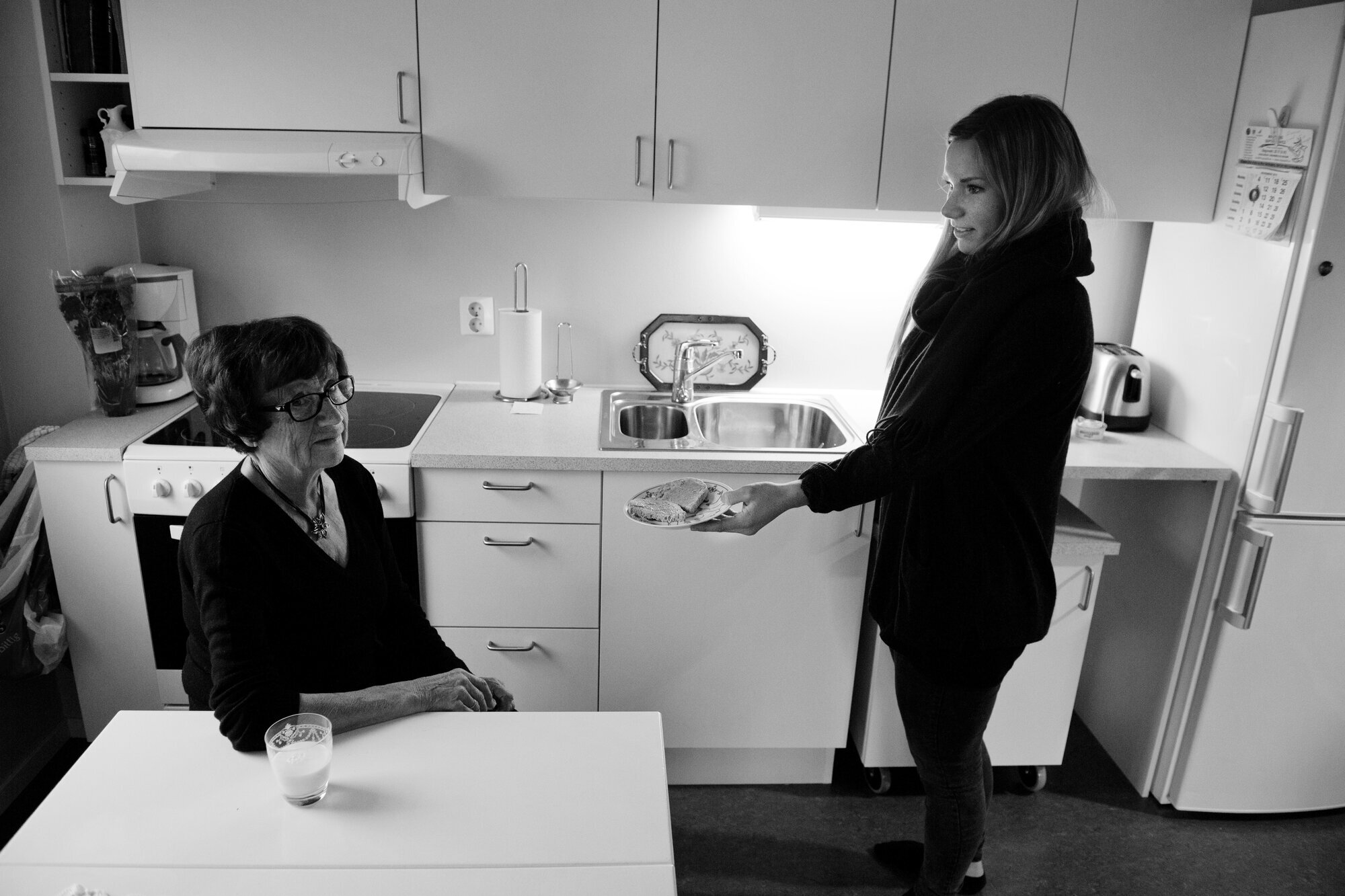 Hjemmesykepleier serverer mat til eldre dame Hjemmesykepleier, mat, eldre