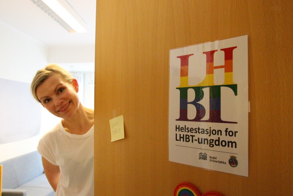 Ingun Wik, helsesøster, sexologisk rådgiver, LHBT-helsestasjonen Biildet viser Ingun Wik som titter ut av en åpen dør på LBHT-helsestasjonen.