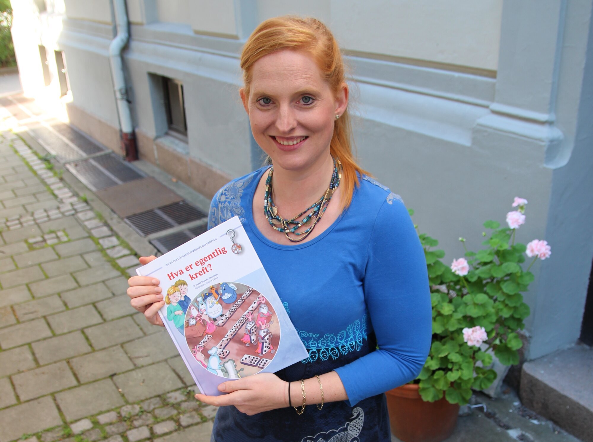 Sarah Roxana Herlofsen, Hva er egentlig kreft Bildet viser Sarah Roxana Herlofsen som holder frem boken sin.