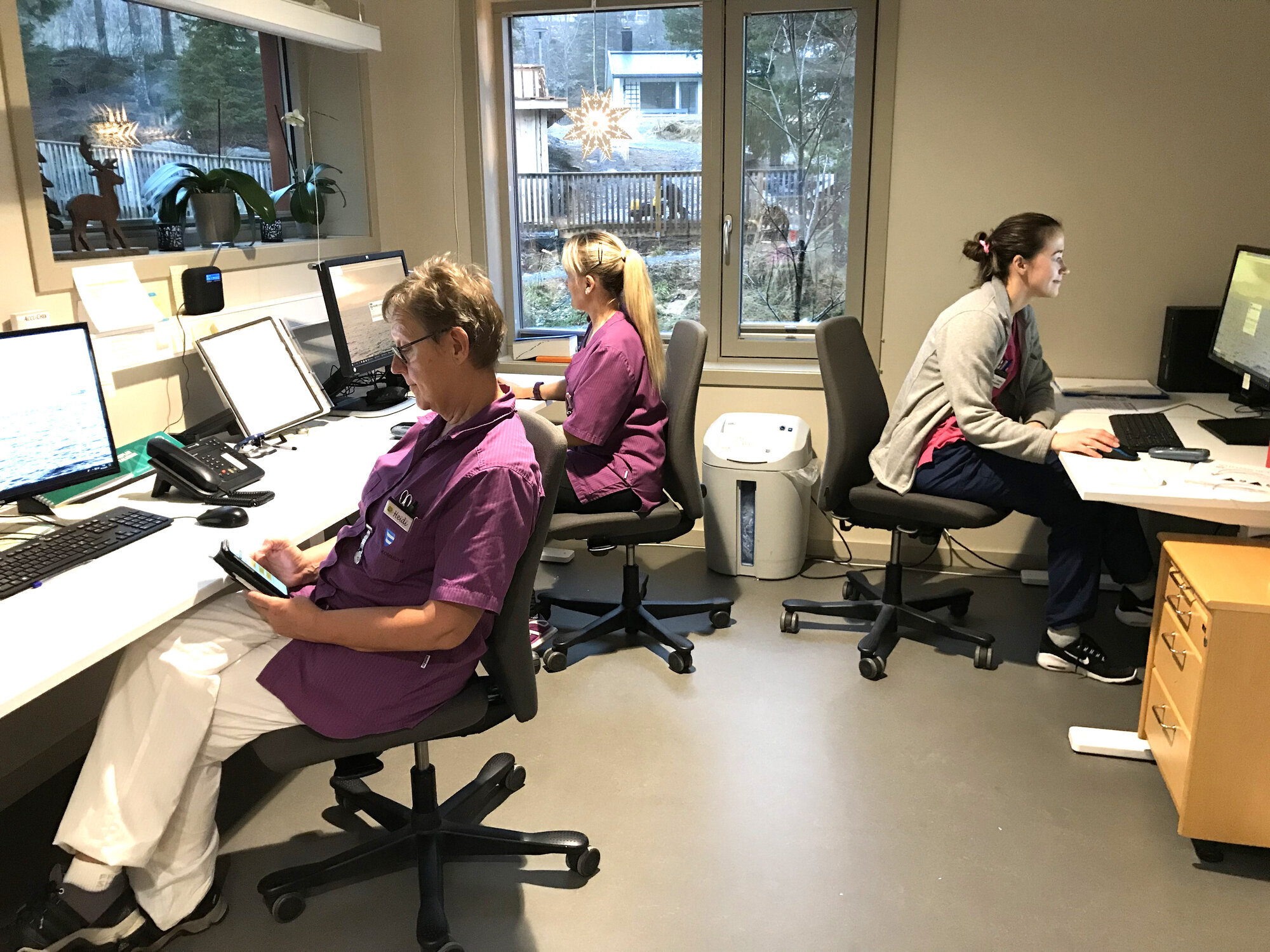 Tre helsearbeidere registrerer i Refleks Bildet viser tre helsearbeidere i Åfjord kommune som registrerer i rapporteringsverktøyet Refleks, både via app på mobiltelefon og via pc.