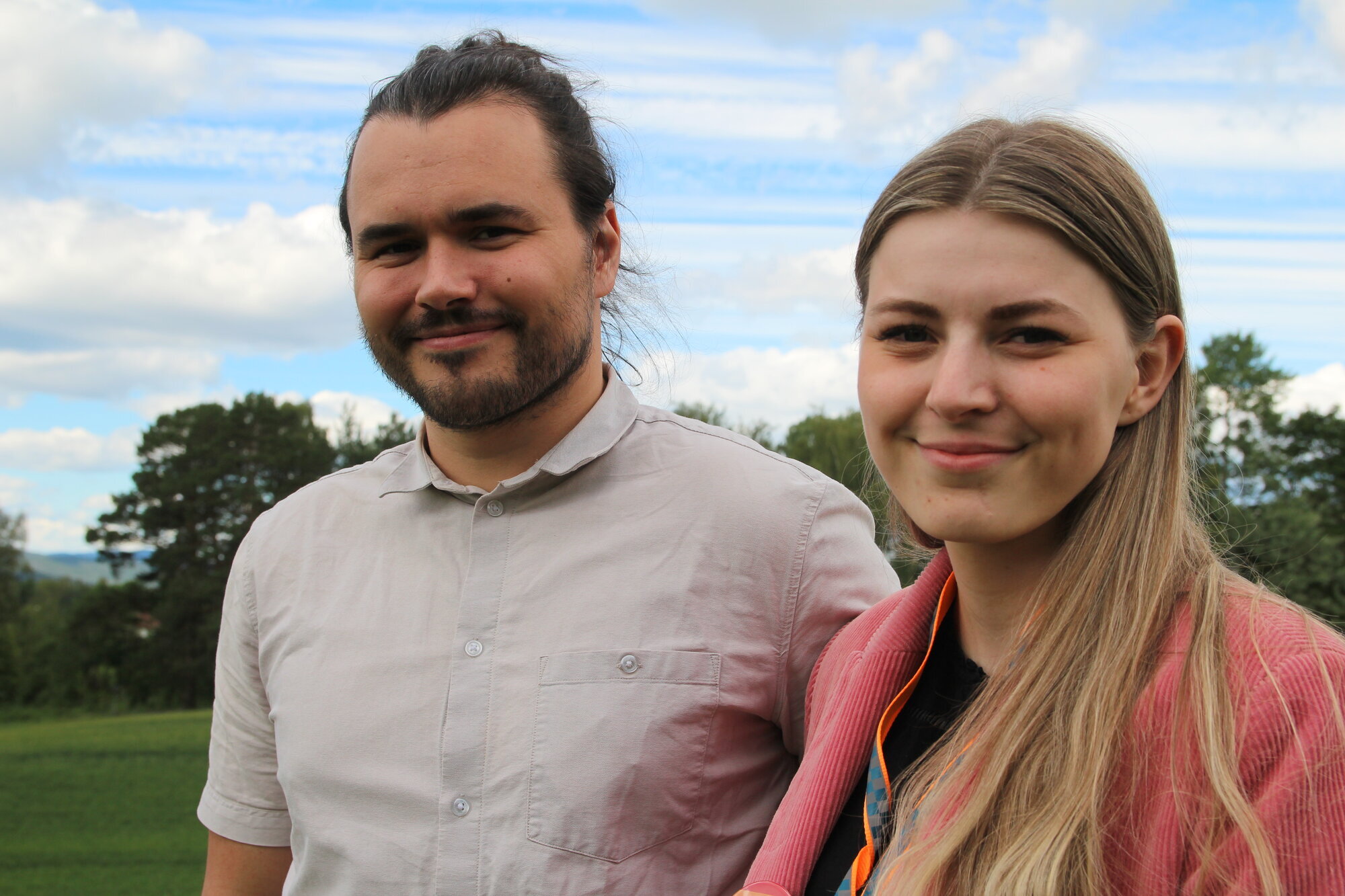 Portrett av ung mann med mørkt hår, ung kvinne med lyst hår. Smiler.