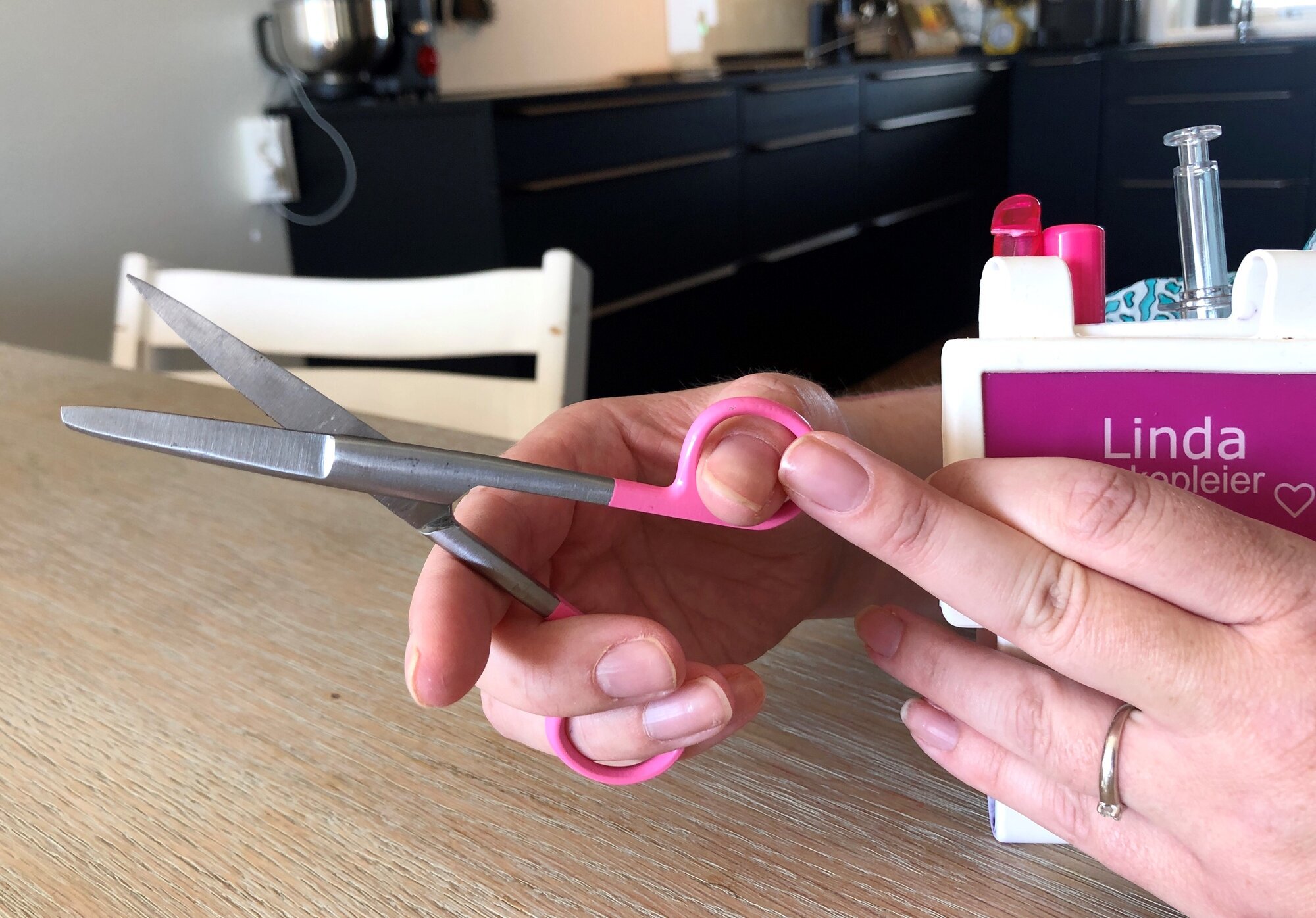 Hånd som griper saks, men må ha støtte fra en annen hånd til å klippe