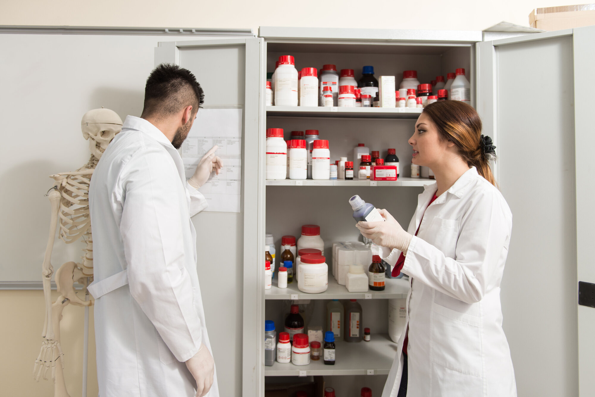 Bilde av to medisinstudenter som kikker inn i et medisinskap Bilde av to medisinstudenter som kikker inn i et medisinskap