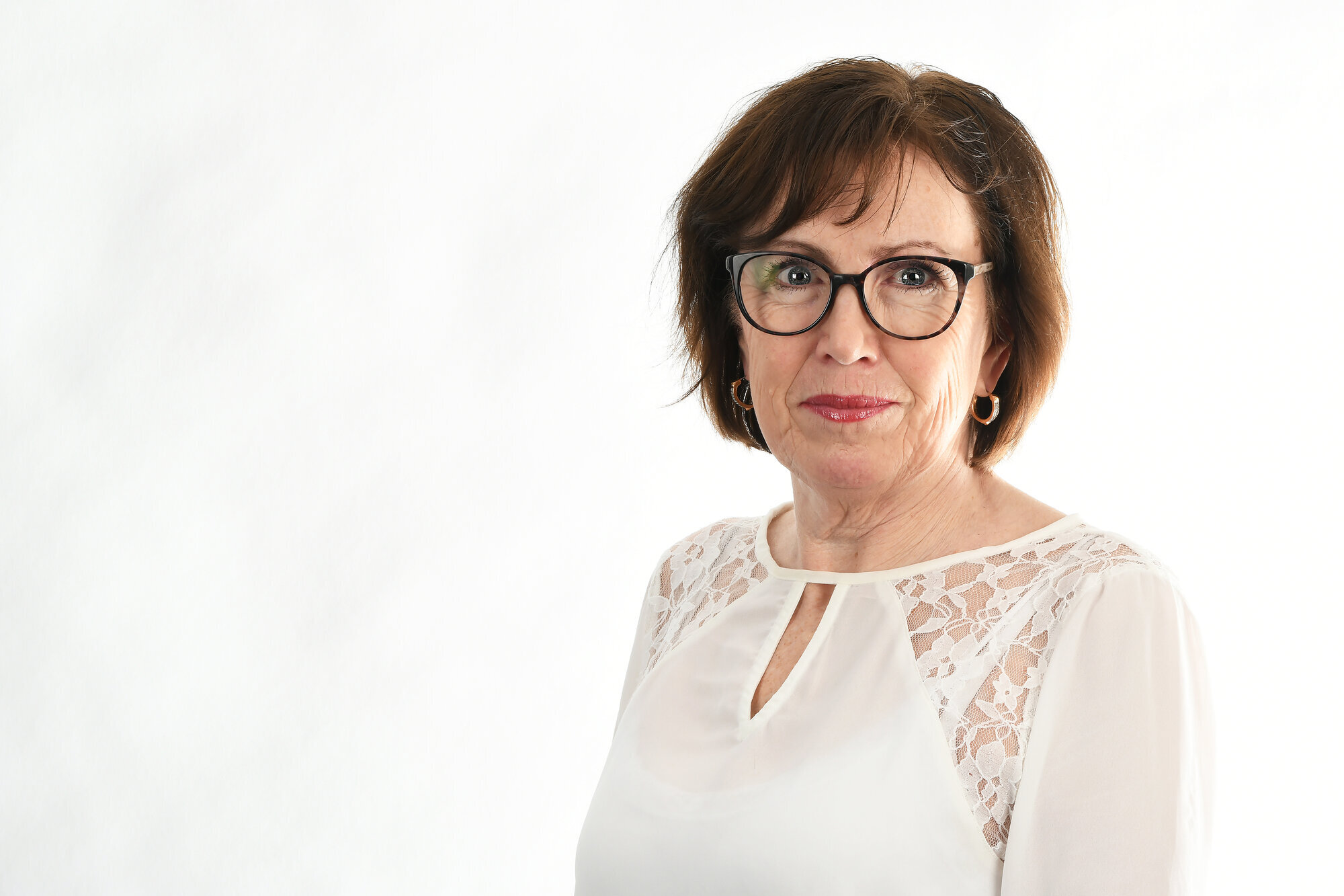 Portett av mørkhåret middelaldrende kvinner med briller og hvis bluse