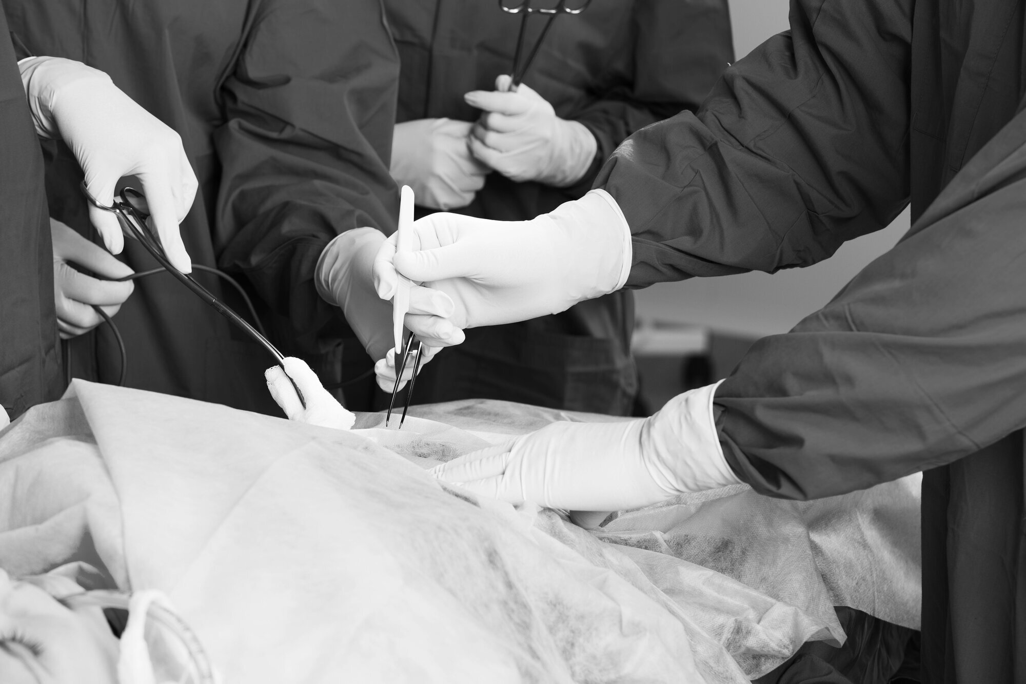 På operasjonsbordet Hender som opererer en pasient