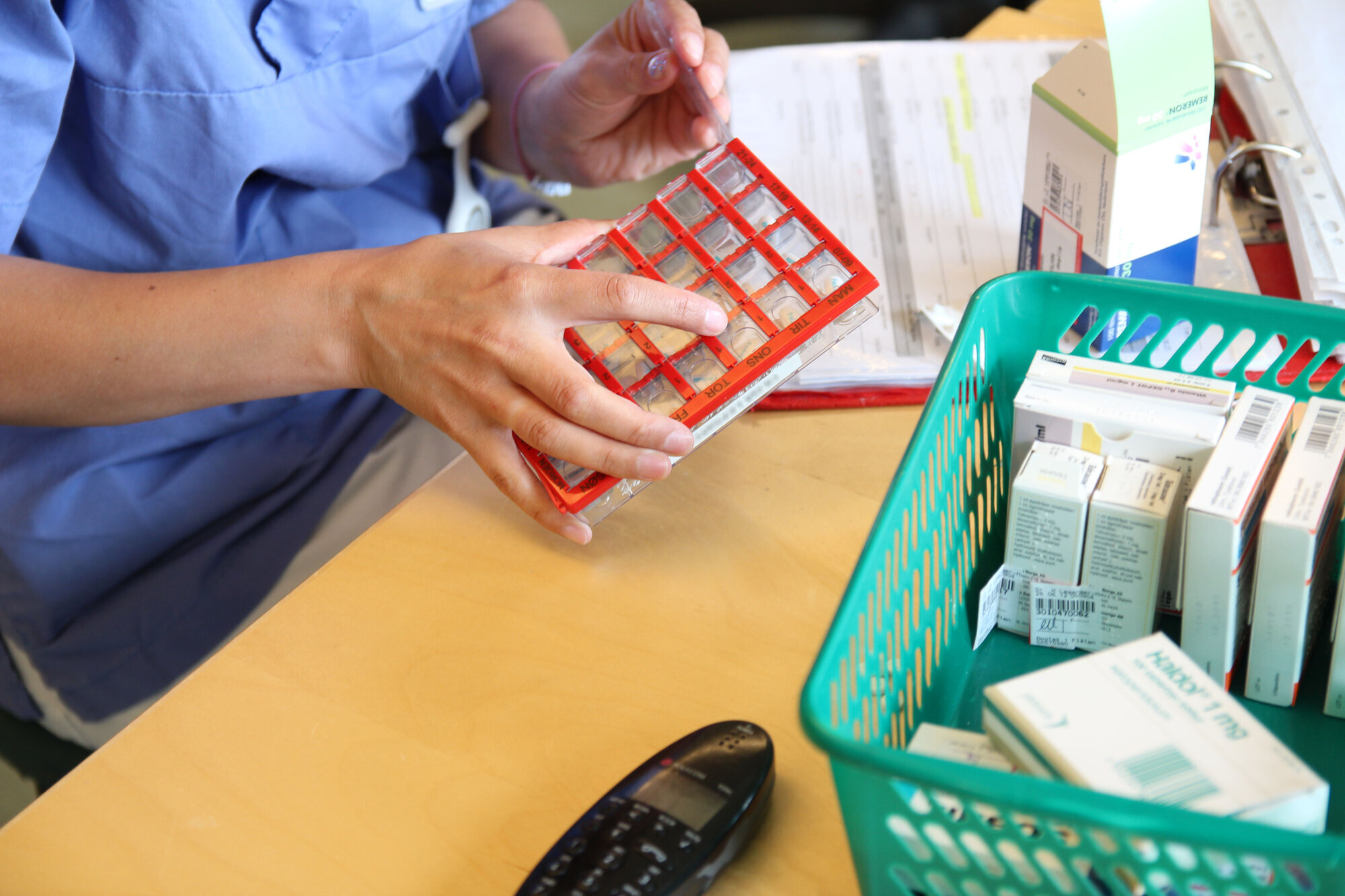 hånd som legger piller i en boks bildet viser hånd som legger piller i boks