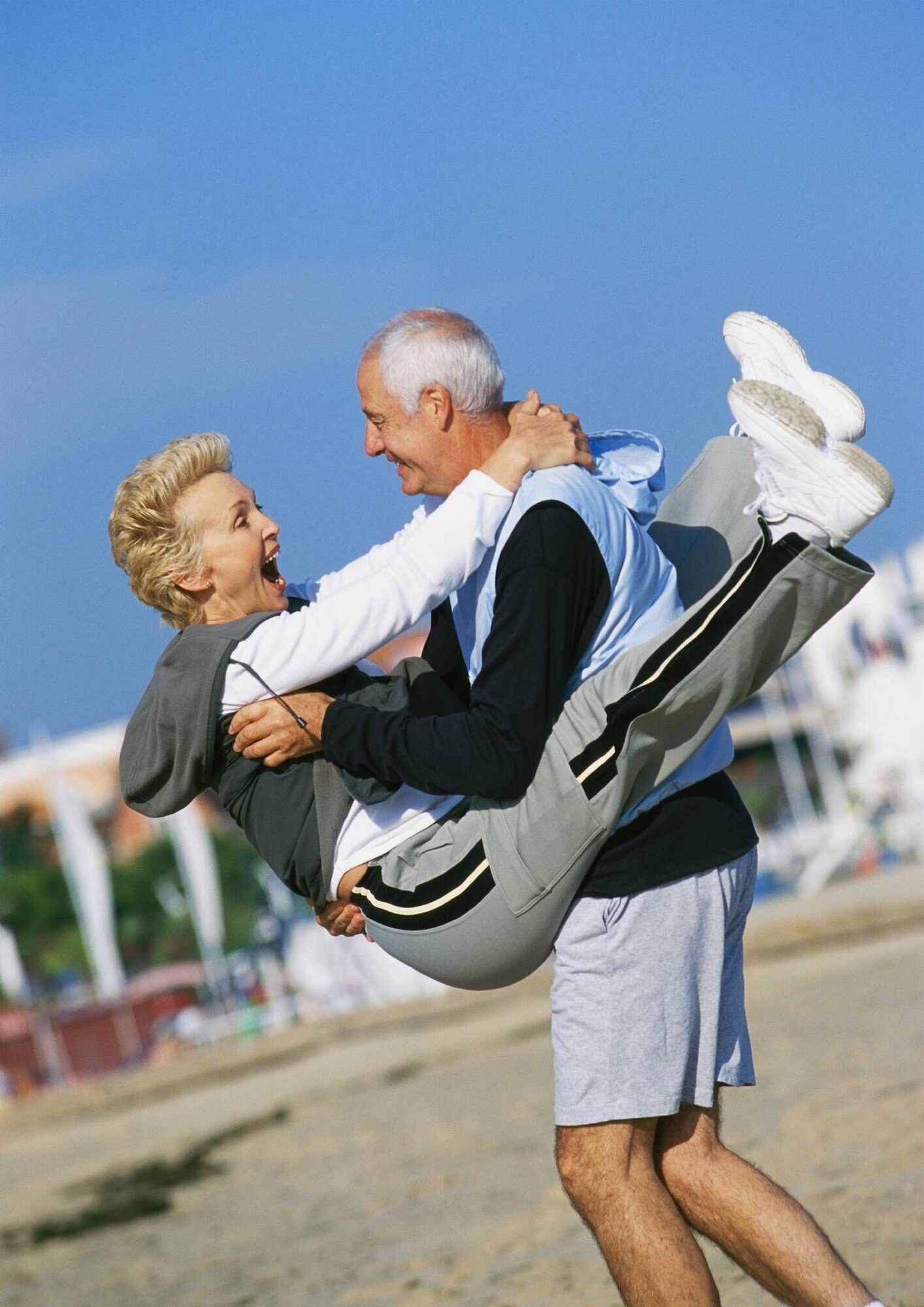 Pensjonist Bilde av eldre kvinne som hopper opp på en eldre mann. Begge smiler og ler