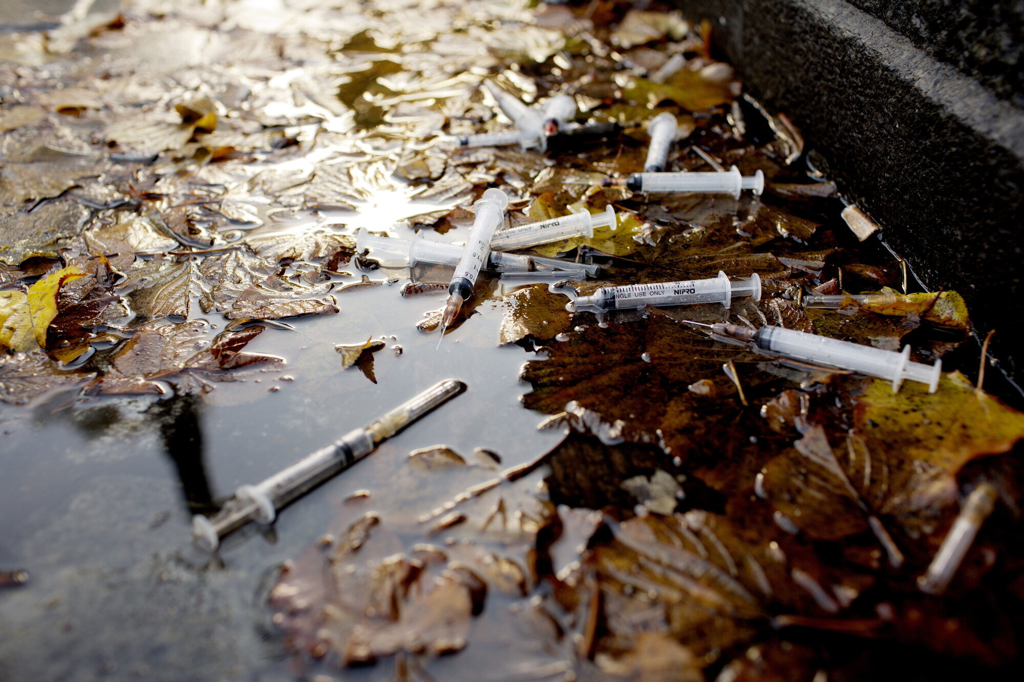 sprøyter, rusmisbruk Bildet viser brukte sprøyter i en vannpytt.