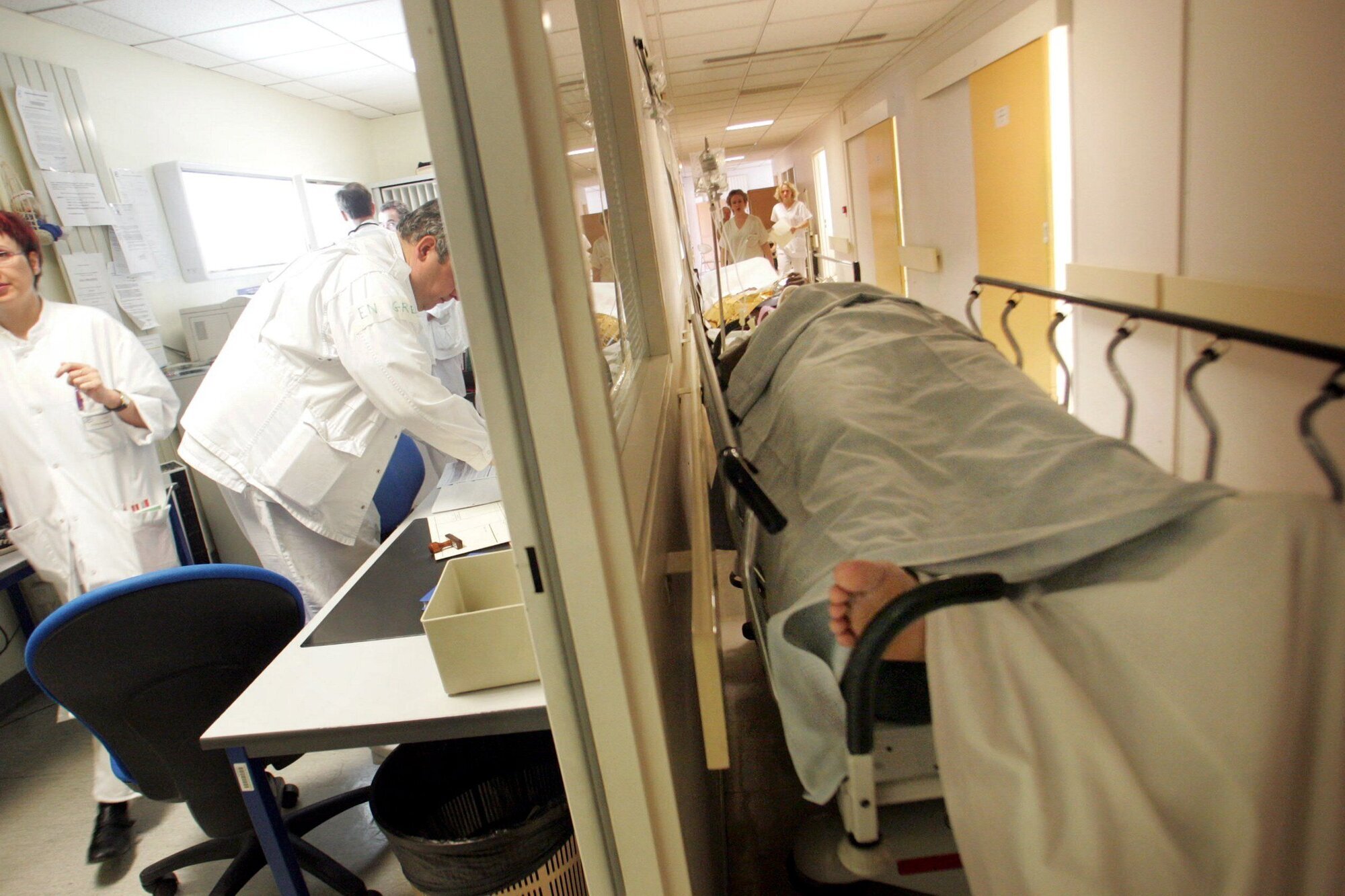 korridorpasient på sykehus Bildet viser korridorpasient på sykehus. Helsepersonell jobber i bakgrunnen