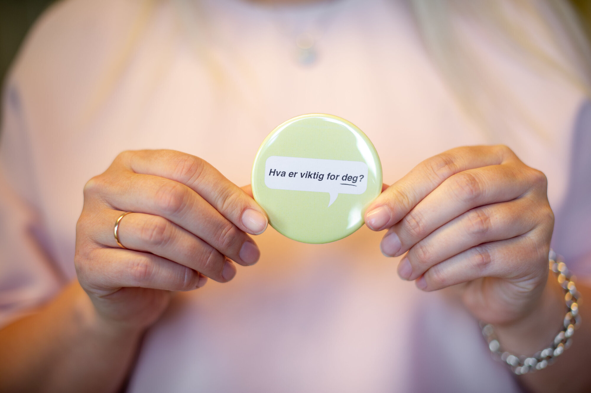 Bodil Bakken Domingos med button med tekst: "Hva er viktig for deg?" Bildet viser Bodil Bakken Domingos med button med teksten "Hva er viktig for deg?"