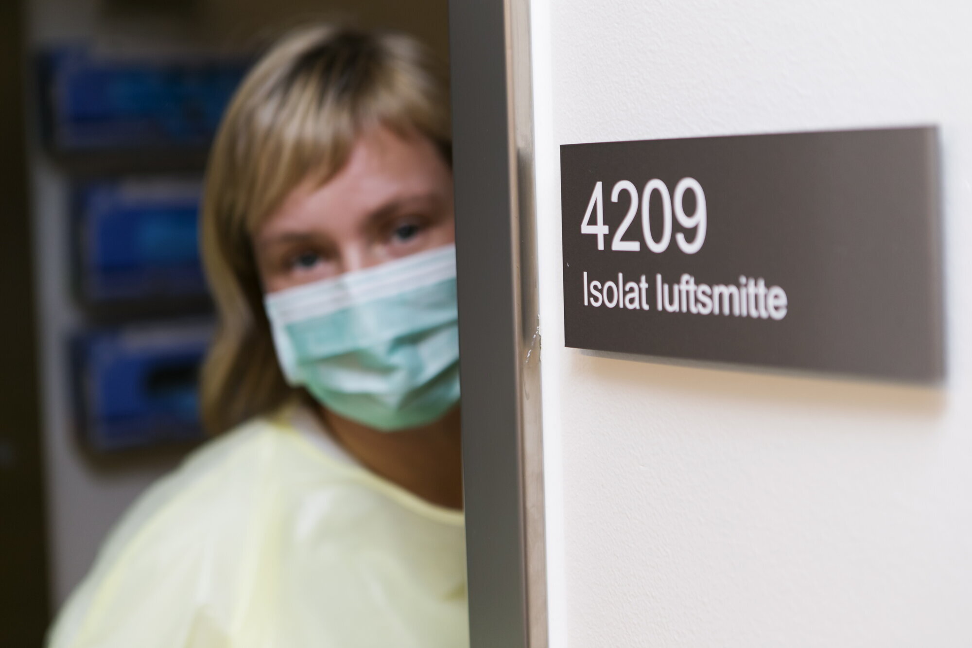 Kvinne med beskyttelsesutstyr. Kvinne i beskyttelsesytstyr utenfor isolat.