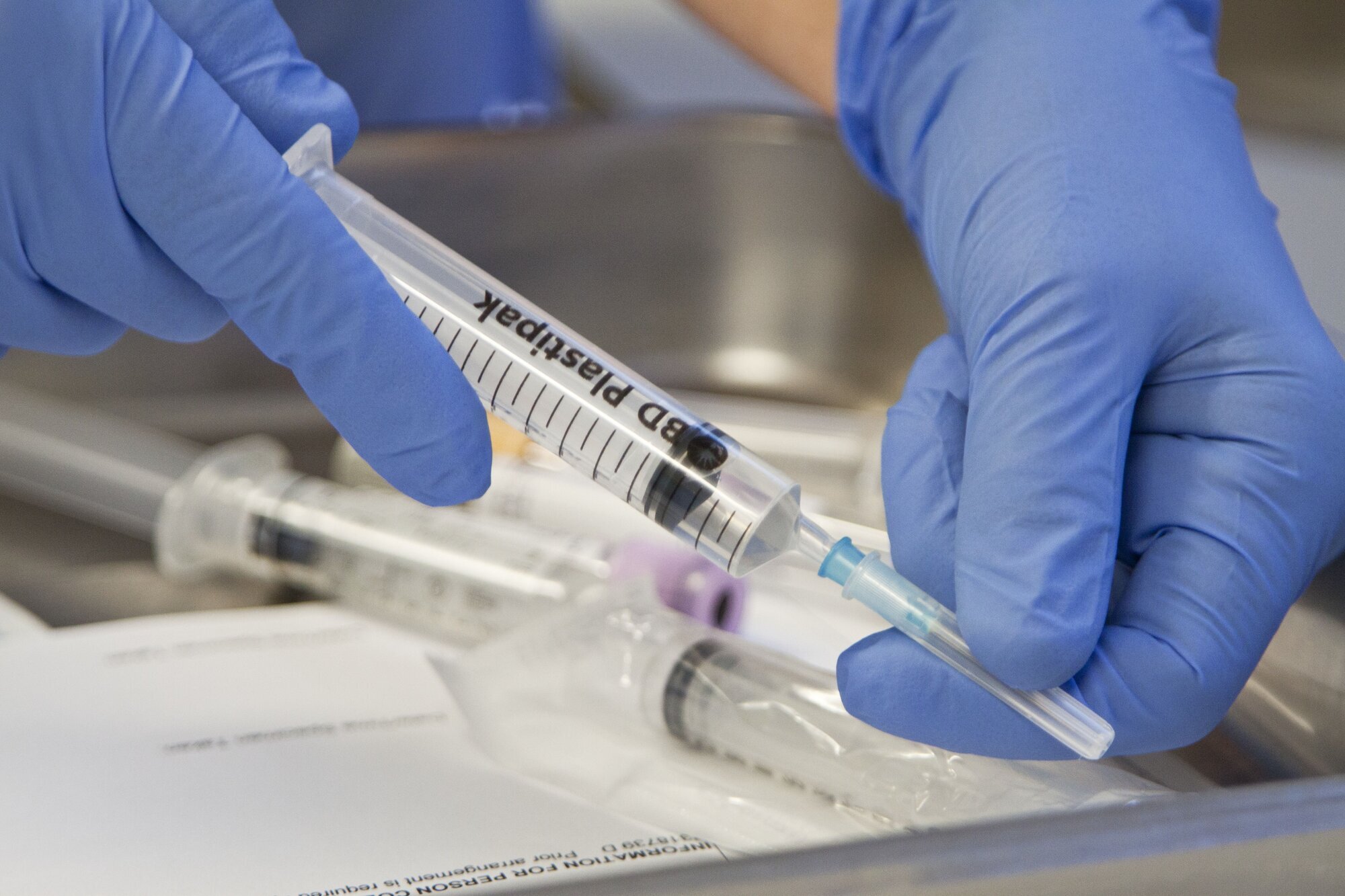 cellegift, legemiddelhåndtering Bildet viser hender som gjør klar sprøyter med cellegift.