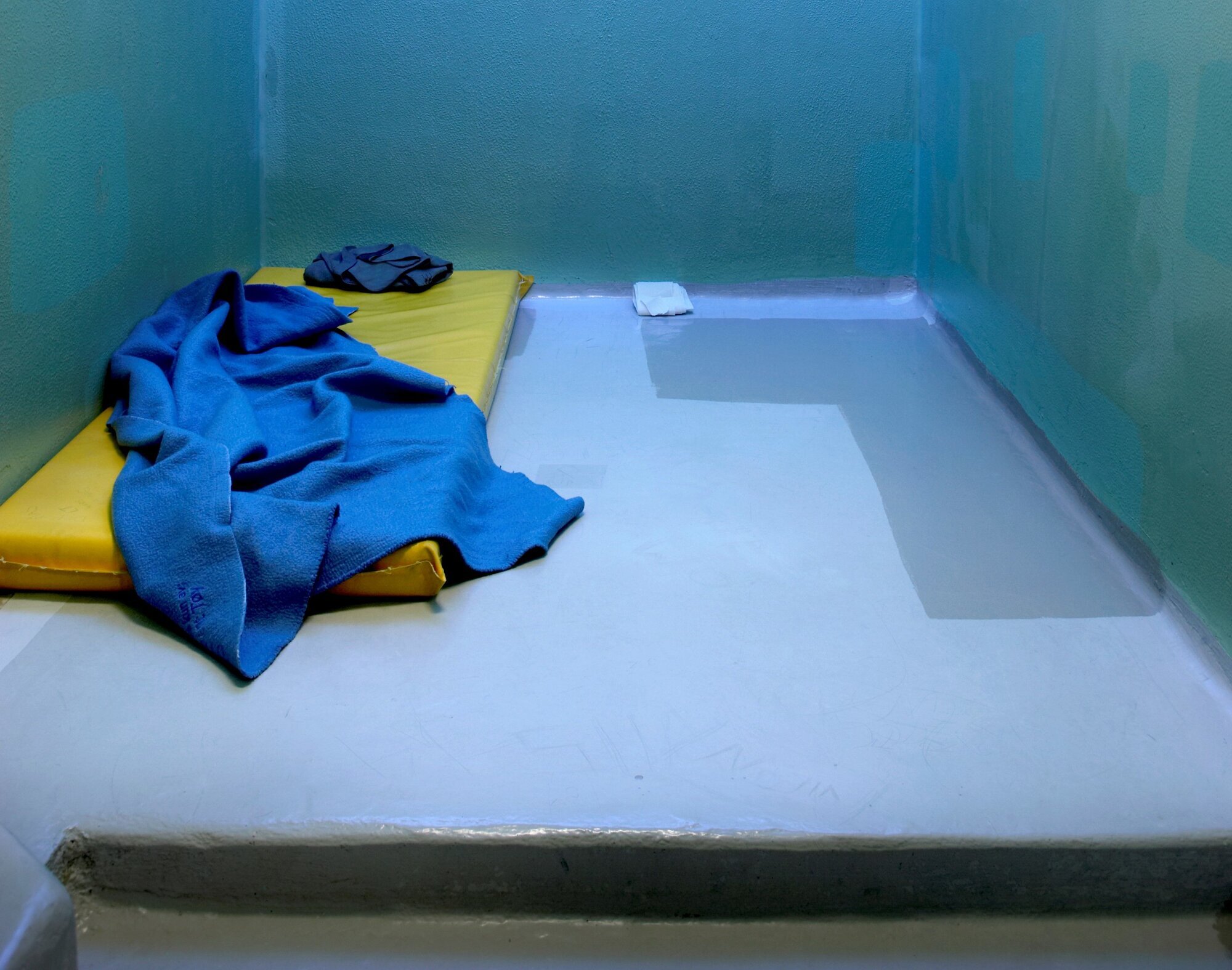 Polstret celle med madrass på gulvet. Isolasjon i fengsel. Polstret celle med madrass på gulvet. Isolasjon i fengsel.