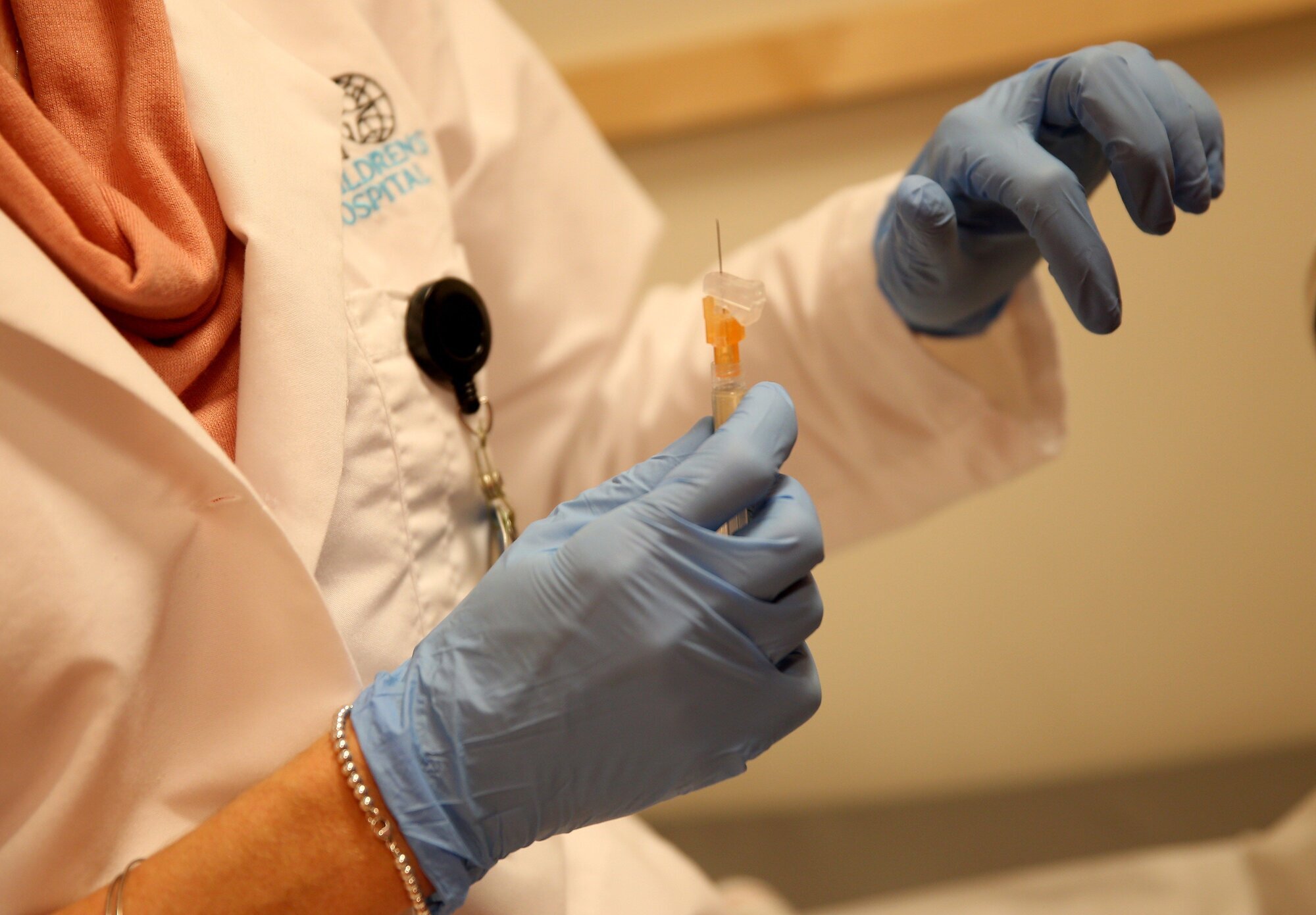 vaksine, meslinger Bildet viser en to hender med hansker som gjør klar en vaksine.