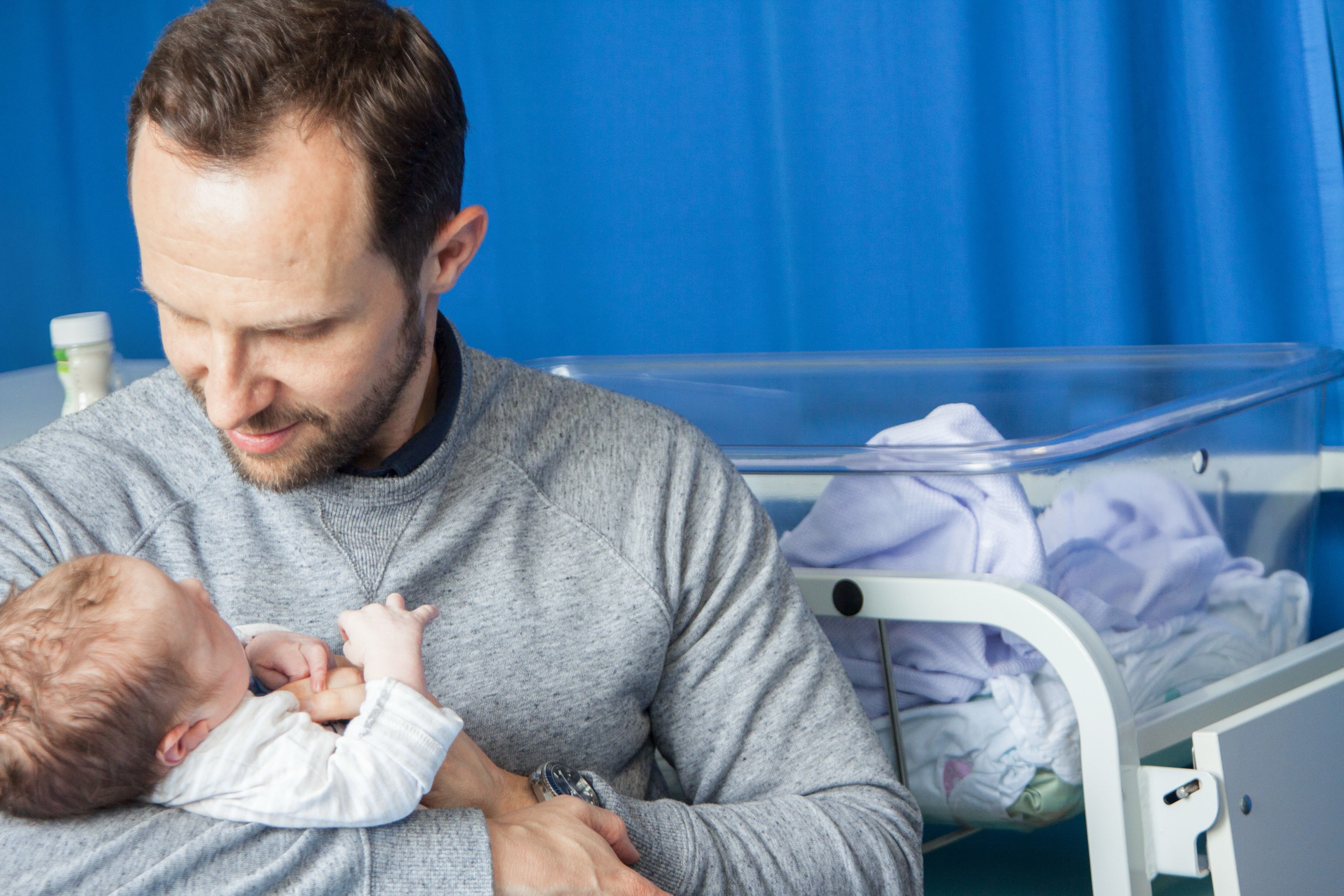 Nyfødt Bildet viser en nybakt far som holder en nyfødt baby