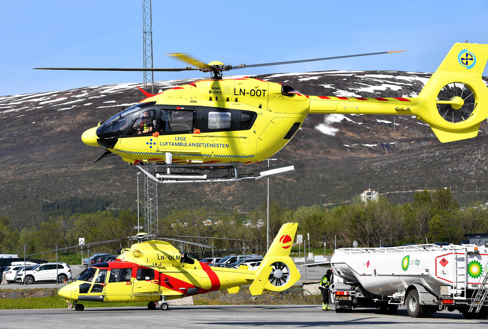 Luftambulanse Bildet viser et ambulansehelikopter som er i ferd med å lette, og et som står på bakken i bakgrunnen