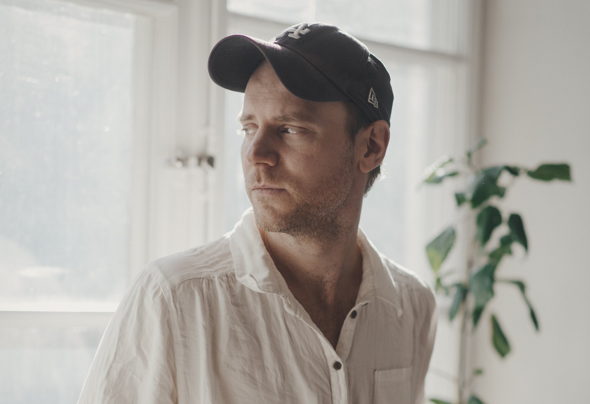 Tom Malmquist, I hvert øyeblikk er vi fremdeles i live Bildet viser Tom Malmquist som ser ut av et vindu.