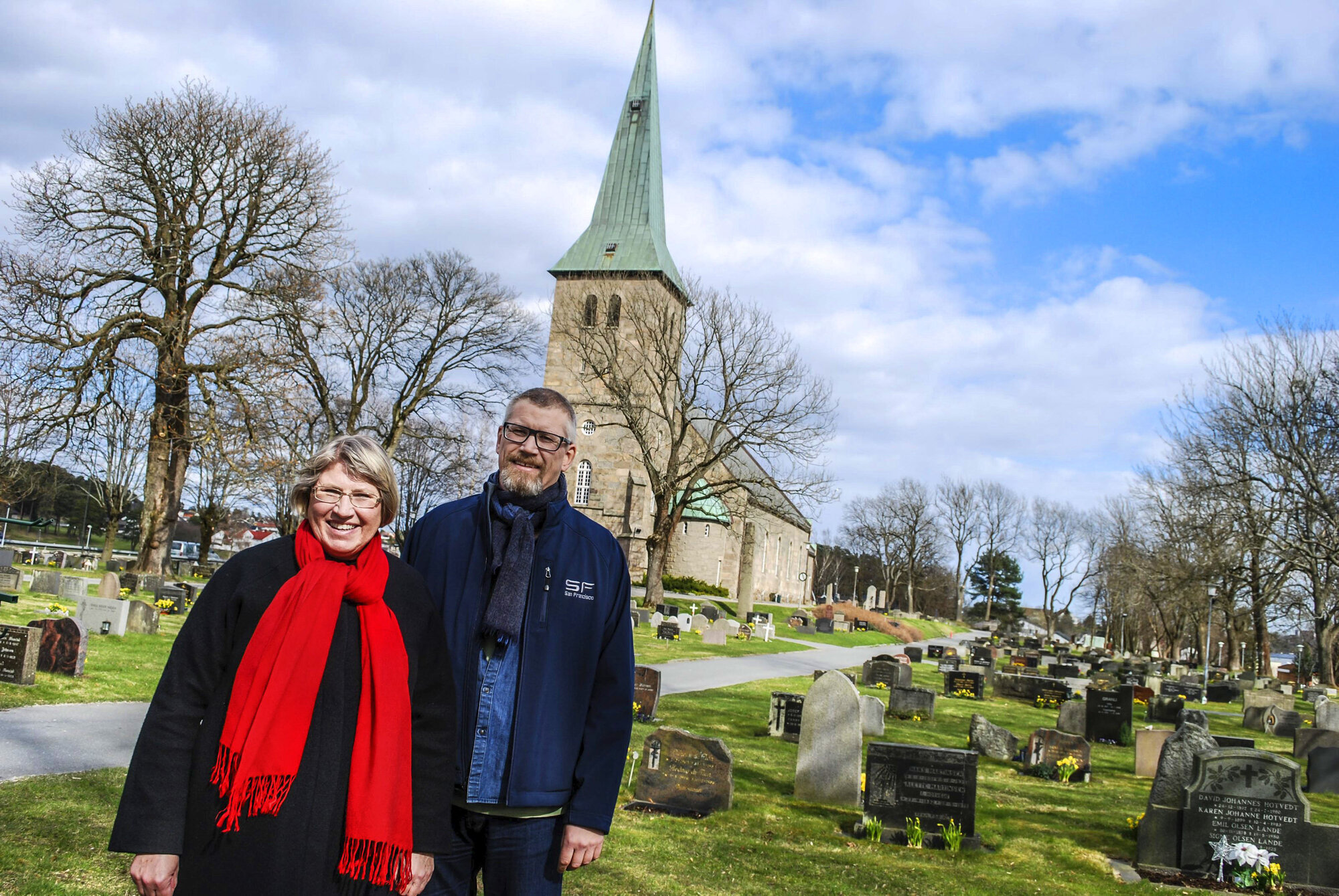 Sogneprestene Lisbeth Heie Gregersen og Petter Johannessen står på kirkegården foran Tune kirke