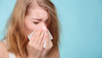 Bildet viser kvinne som nyser