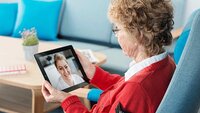 Eldre dame snakker med sykepleier via nettbrett. Eldre dame snakker med sykepleier via nettbrett.