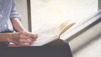 Kvinne leser i dagbok Bildet viser en kvinne som leser i en dagbok