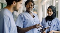 Sykepleiere Bildet viser tre sykepleiere som står og prater sammen