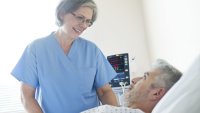 En sykepleier snakker med en pasient En sykepleier snakker med en pasient