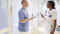 Bildet viser to sykepleiere som snakker sammen