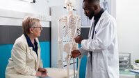 Bilde av lege og pasient med skjelett