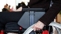 Bildet viser et utsnitt av en person som sitter i rullestol Bildet viser et utsnitt av en person som sitter i rullestol
