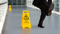 Bildet viser mann som faller på vått gulv