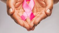 Brystkreft Rosa brystkreftsløyfe som holdes i hender