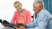 Senior couple looking at photo album Senior couple looking at photo album in a retirement home
